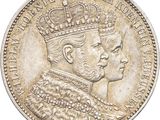 a close up of a silver coin with a crown on it