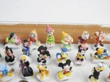 mickey mouse figurines are lined up on a white surface