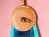 blue and green ribbon with a leather badge hanging from it