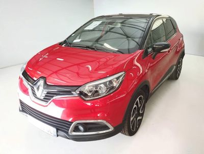 La voiture rouge est garée sur le sol blanc de la pièce.