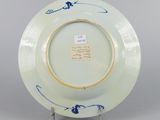 underside view of a blue and white plate with a bird on it