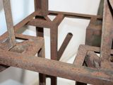 an old rusty metal chair with a wooden seat