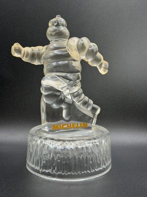 a clear glass figurine of a man holding a baby