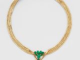 un collier en or avec un pendentif en pierre verte