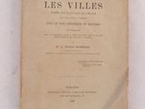 un vieux livre posé sur une table à côté d'un mur blanc