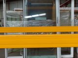 un banc jaune qui se trouve devant des fenêtres