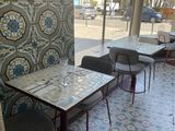 tables and chairs in a restaurant with a view of the street