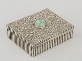 an antique silver box with a turquoise stone in the center