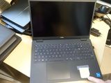 laptop computer sitting on a desk next to a person ' s hand holding a credit card