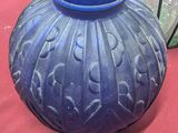 a blue vase sitting on a table with other vases in the background