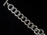 a close up of a silver bracelet on a black background