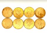 six gold coins are arranged in a row on a white surface