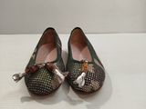 une paire de chaussures pour femme ornées de nœuds, posée sur une table