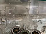 une étagère en verre sur laquelle sont posés de nombreux objets en verre