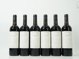 six bouteilles de vin sont alignées sur une table