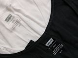 two white and black shirts are sitting next to each other on a table