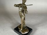statue en bronze représentant une femme tenant une épée, posée sur un socle en marbre