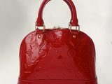 a close up of a red handbag on a white background