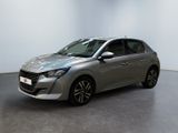 La voiture argentée est garée dans une pièce blanche au sol noir.