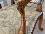 a wooden chair with a patterned upholstered back and arms