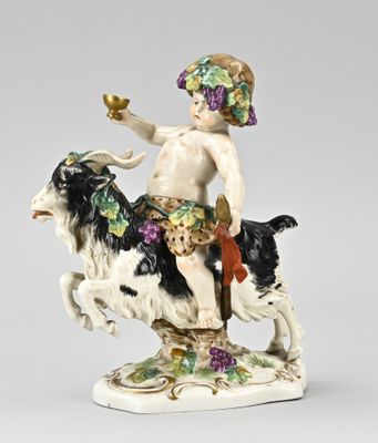 figurine of a boy on a cow with grapes on his head