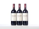 three bottles of red wine sitting next to each other on a table