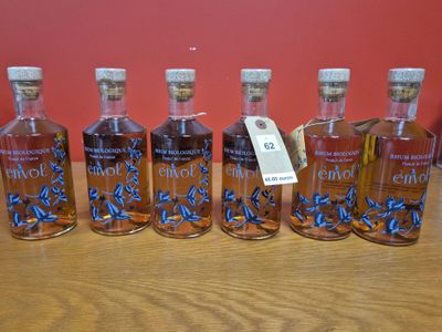 six bouteilles d'alcool sont alignées sur une table