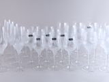 de nombreux verres à vin vides alignés sur une surface blanche