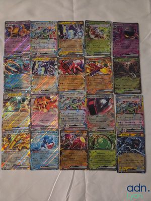 a pile of pokemon cards sitting on top of a white sheet