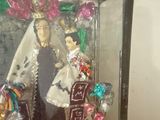 a glass case with a doll in it on a table