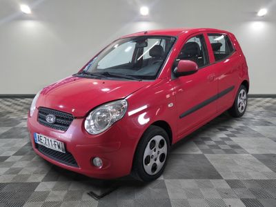 a picture of a red small car parked in a garage