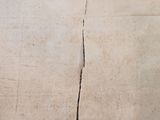 a crack in the wall of a room with a clock on it