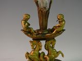 a glass vase with a gold base on a table