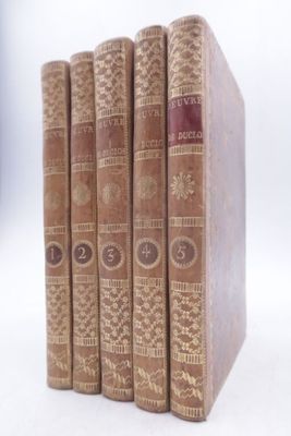 quatre livres sont alignés sur une surface blanche