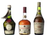 three bottles of liquor are lined up on a white surface