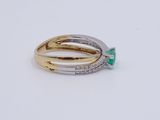a gold and silver ring with an emerald stone and diamonds