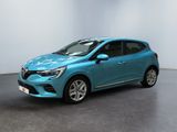 Une voiture bleue est garée dans une pièce aux murs blancs.