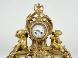 a gold clock with angels on it on a white background