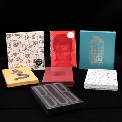 Quatre boîtes de chocolats sont alignées sur une surface noire