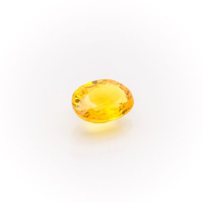 a yellow sapphire stone on a white background