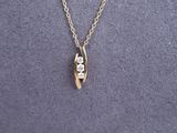 a gold necklace with a white diamond on it