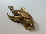 a gold fish that is sitting on a white surface