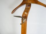 un porte-manteau en bois sur lequel sont posées une paire de ciseaux
