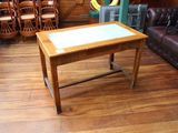 une table en bois avec un plateau en verre, posée sur un parquet