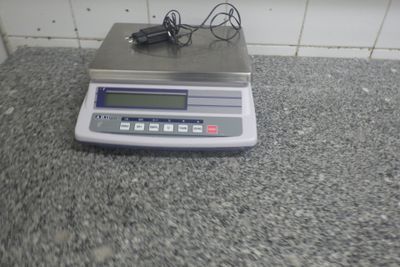 a electronic scale on a counter with a charger on it