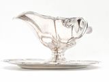 a silver plate with a silver gravy on it