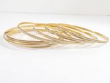 a set of five gold bangies with diamonds on them