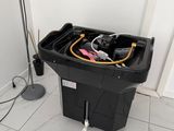 a black trash can sitting on the floor next to a floor lamp
