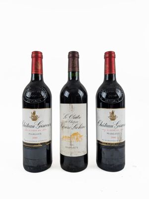 trois bouteilles de vin rouge sont alignées sur une surface blanche