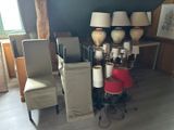 une pièce avec beaucoup de chaises et de lampes posées sur la table